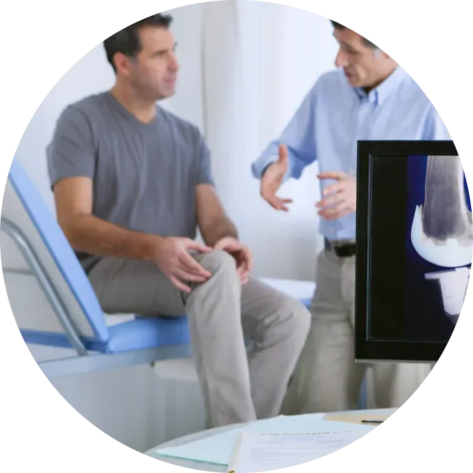 Doctor discussing knee injury with patient in clinic.